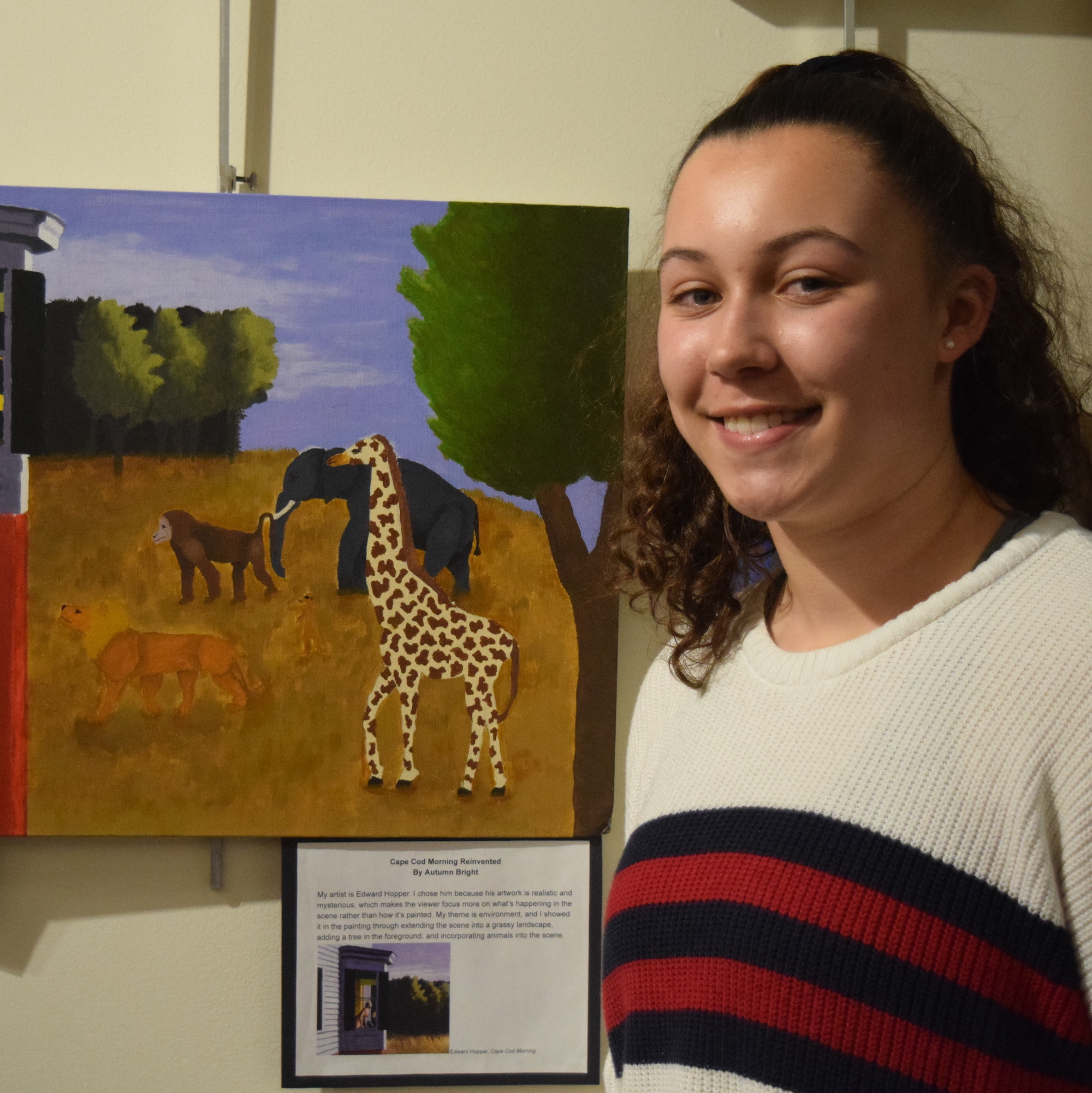 A student stands by her artwork displayed at the 51Թ.